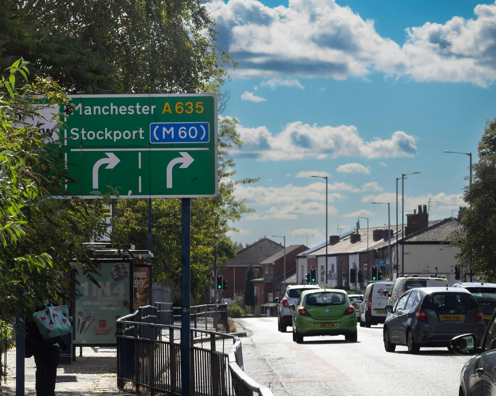 Road sign for manchester and stockport with traffic.