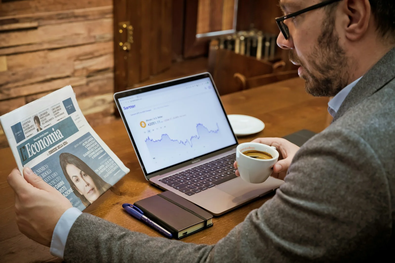 a man sitting at a table with a laptop and a cup of coffee a man sitting at a table with a laptop and a cup of coffee