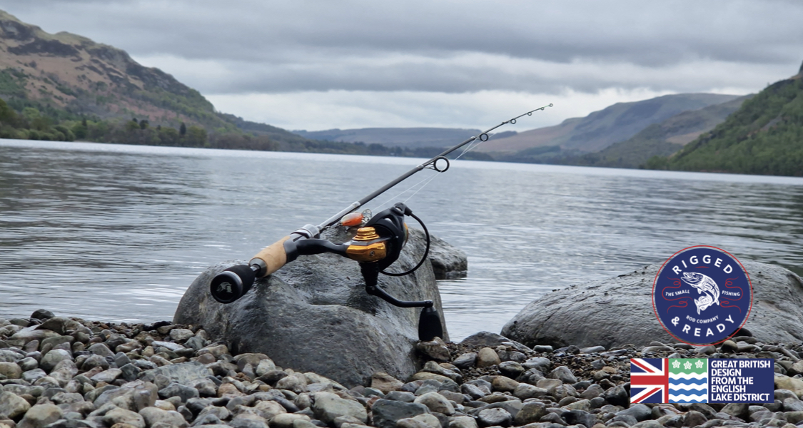 Beginner Fishing Tackle Checklist - Editorial photograph of a small roach resting on a wet padded unhooking mat on a Quality spinning rod and gold-accented reel with a lure, resting on a rock beside a lake